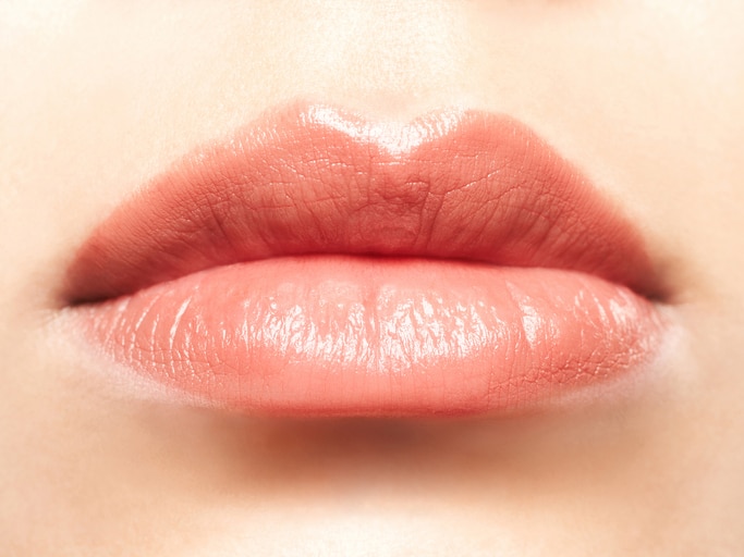 Close-up of a woman's plump pink lips.  Horizontal shot.