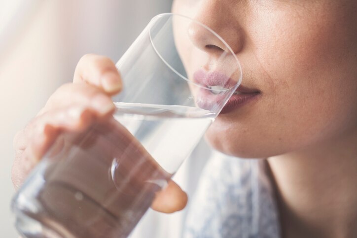 Young woman drinking pure glass of water