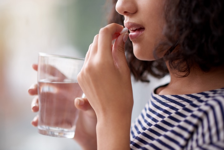 Cropped shot of an unrecognizable teenage girl drinking medication