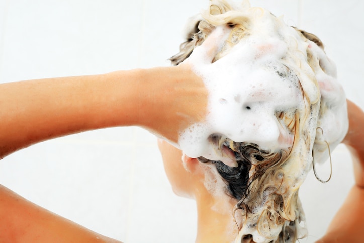 "Woman shampooing hair, doing shower in bath room. White background."