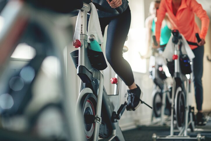 Cropped shot of women working out with exercise bikes in a exercising class at the gym