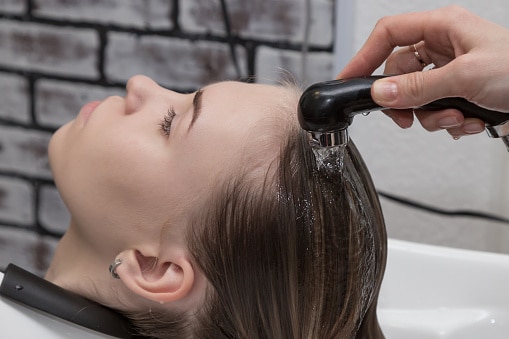 Cropped Hand Washing Woman Hair In Salon