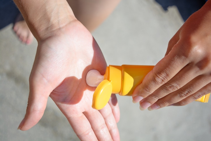 Female hands with sun protection cream. Skin care concept.