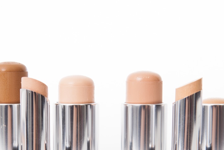 Close-up of make-up concealer sticks in different shades of beige