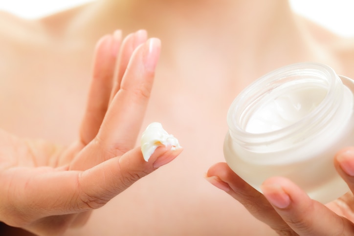 Skincare. Woman taking care of her dry complexion. Moisturizing cream in female hands isolated. Beauty treatment.