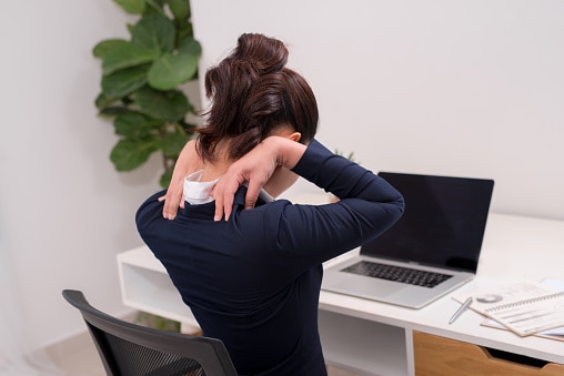 Close up Rear View of a Tired Businesswoman Holding her Nape with Two Hands.