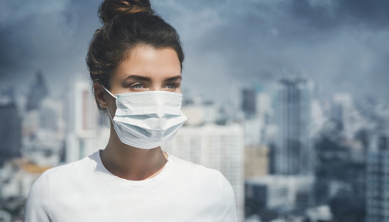 Woman wearing face mask because of air pollution in the city