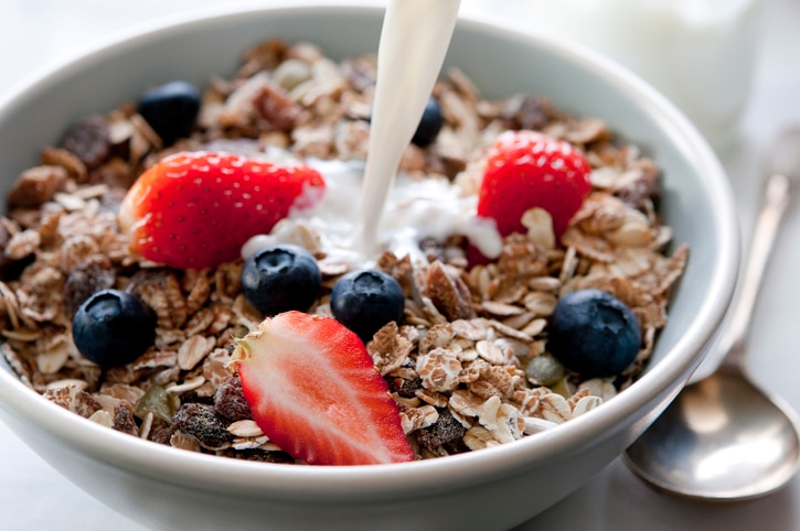 Closeup of a bowl of granola with fresh fruit and milk. Selective focus; shallow depth of field.Related Images: