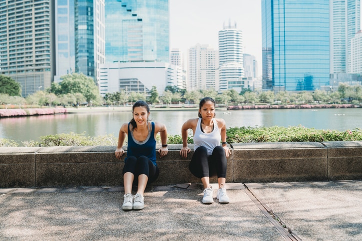 Young women exercising together outdoor in the city