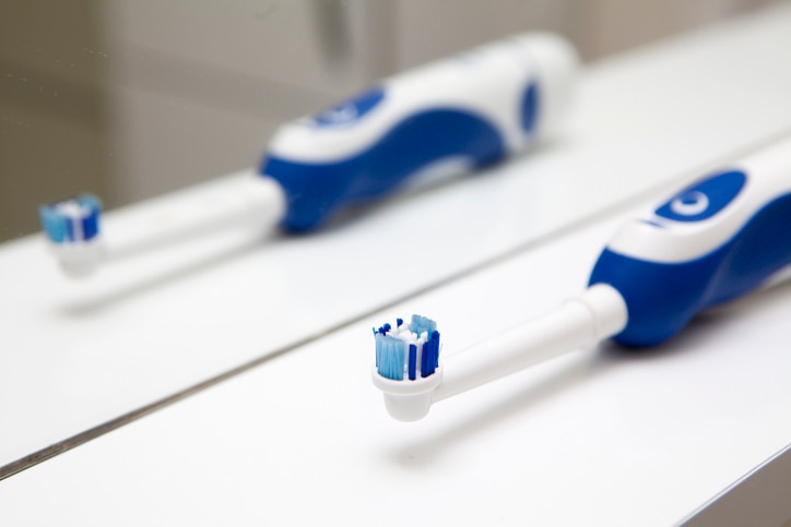 Electric toothbrush front of mirror in bath