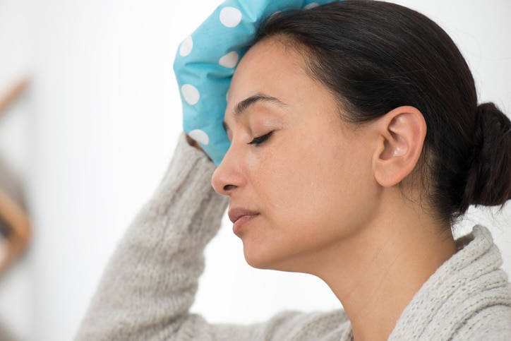 Woman with ice pack. Flu and fever.