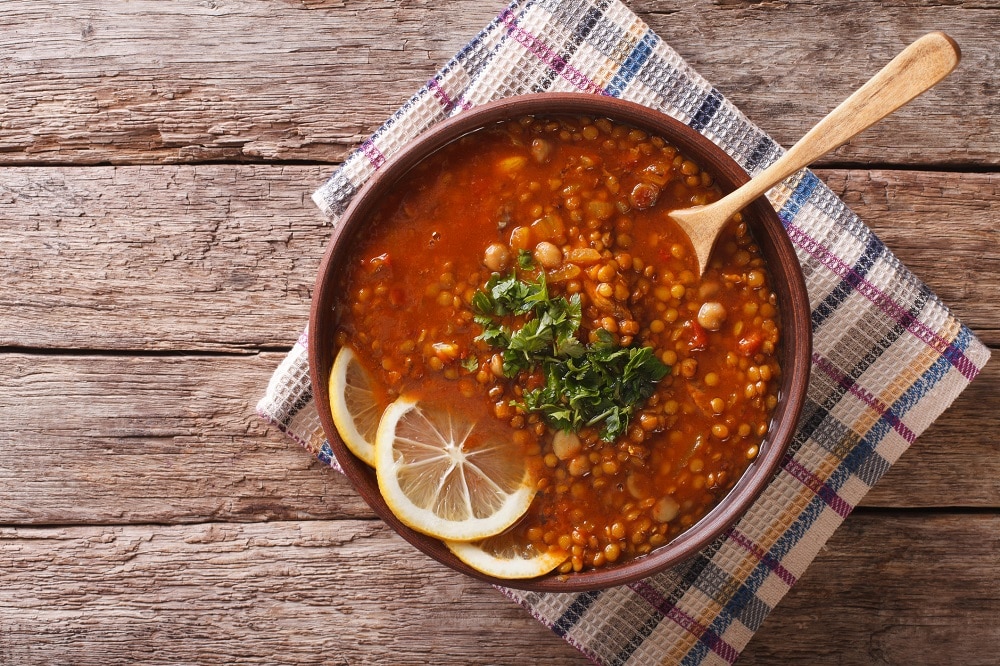 Thick Moroccan Harira soup in a bowl close-up on the table. Horizontal view from above