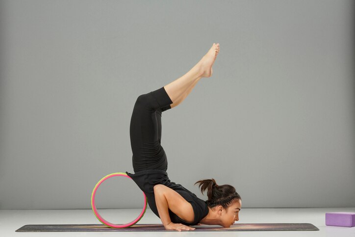 Yoga. Athletic young woman practicing advanced yoga sports training. Yoga wheel poses. Gymnastics exercise. Fitness, stretching training. Health club.