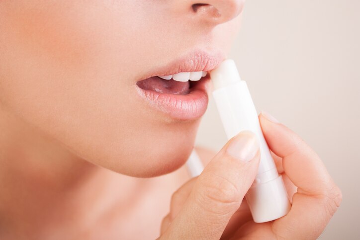 woman applying balsam on lips