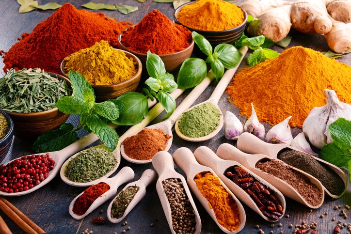 Variety of spices and herbs on kitchen table.