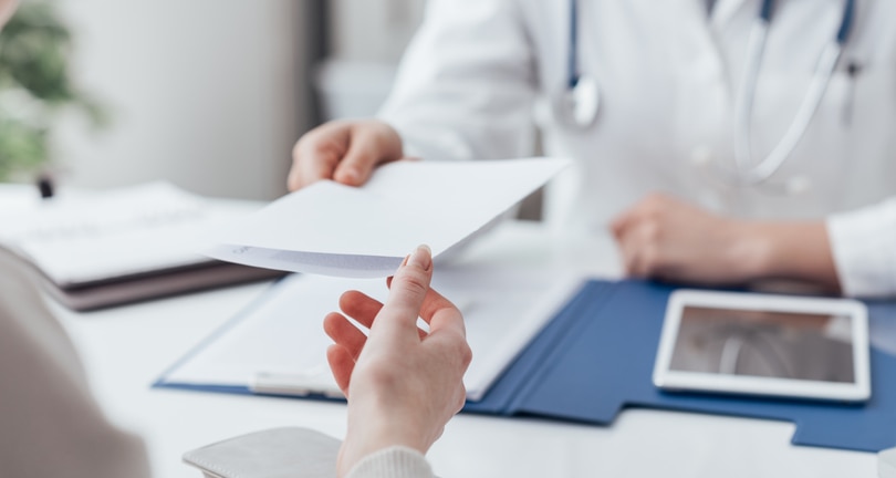 Female doctor meeting with a patient in the office, she is giving a prescription to the woman, healthcare and medicine concept