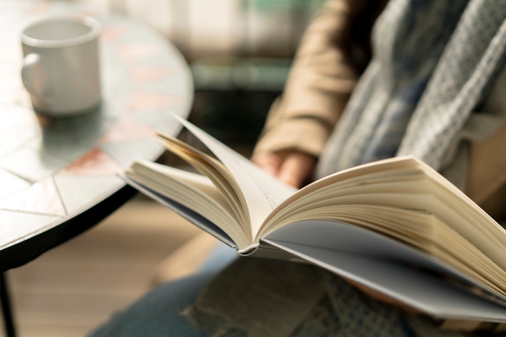 Reading book while drinking coffee on balcony