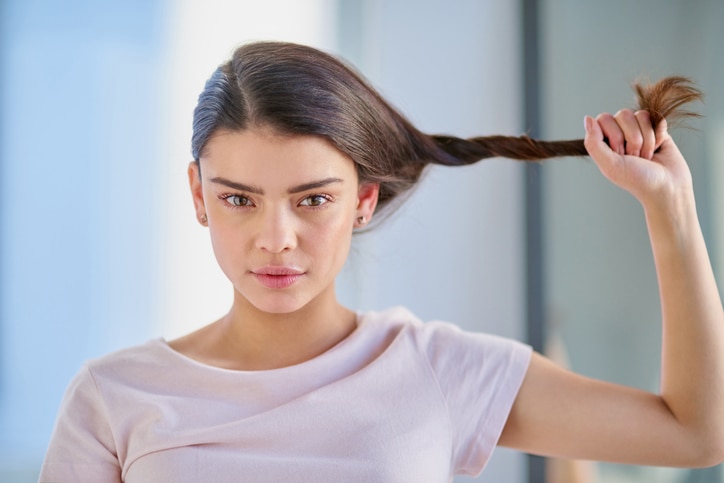 Cropped portrait of a beautiful young woman stretching her gar out in the bathroom at home