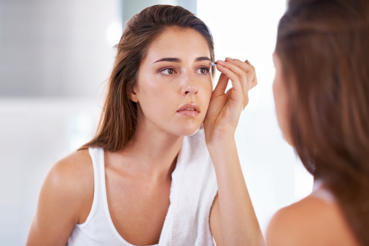 A young woman tweezing her eyebrows in front of a mirrorhttp://195.154.178.81/DATA/i_collage/pi/shoots/783538.jpg