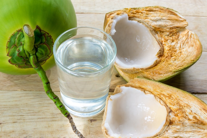 coconut water and fresh coconut on wooden background