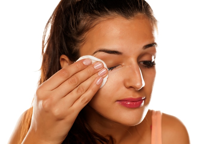 young beautiful woman remove her make-up with cotton pad