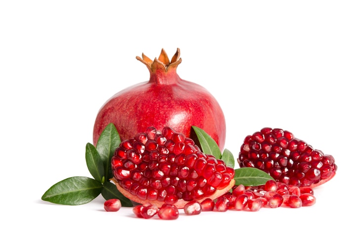 whole and part of Pomegranate with leaves isolated on white