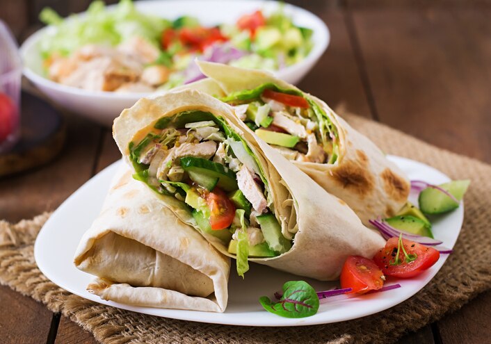 Fresh tortilla wraps with chicken and fresh vegetables on plate