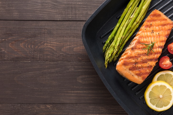 Grilled salmon cooked BBQ on a pan on wooden background.