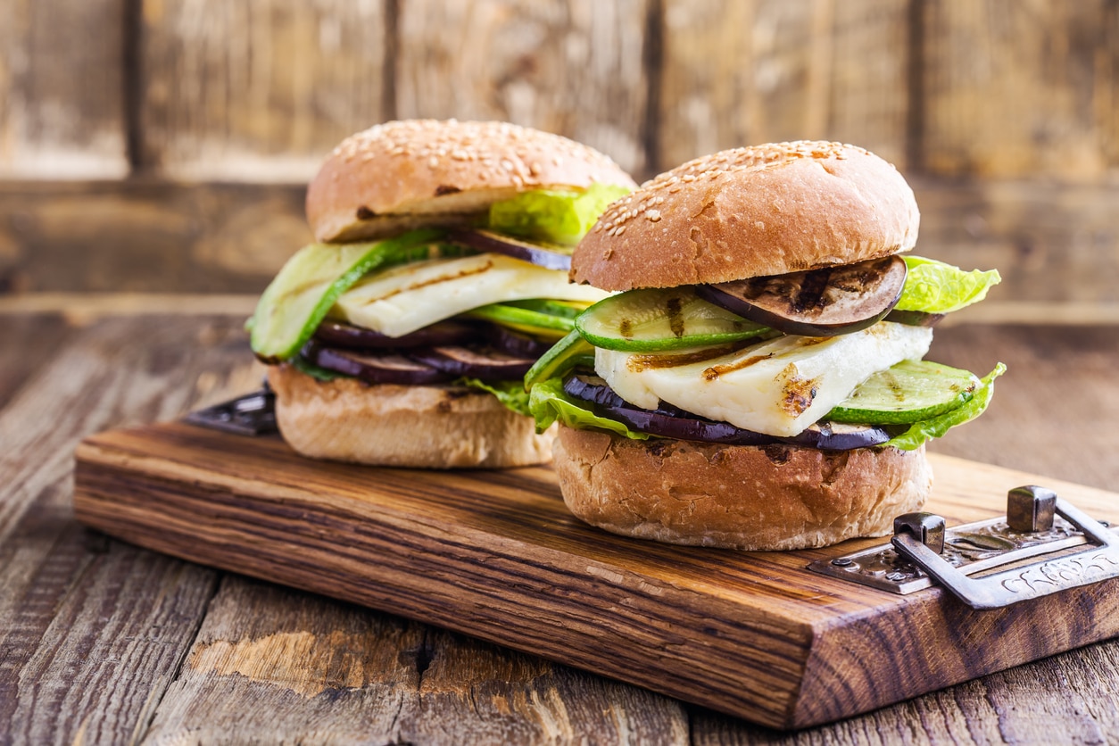 Grilled vegetable and haloumi burger with romaine lettuce on wooden table